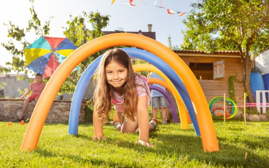 kids crawling under pool noodles
