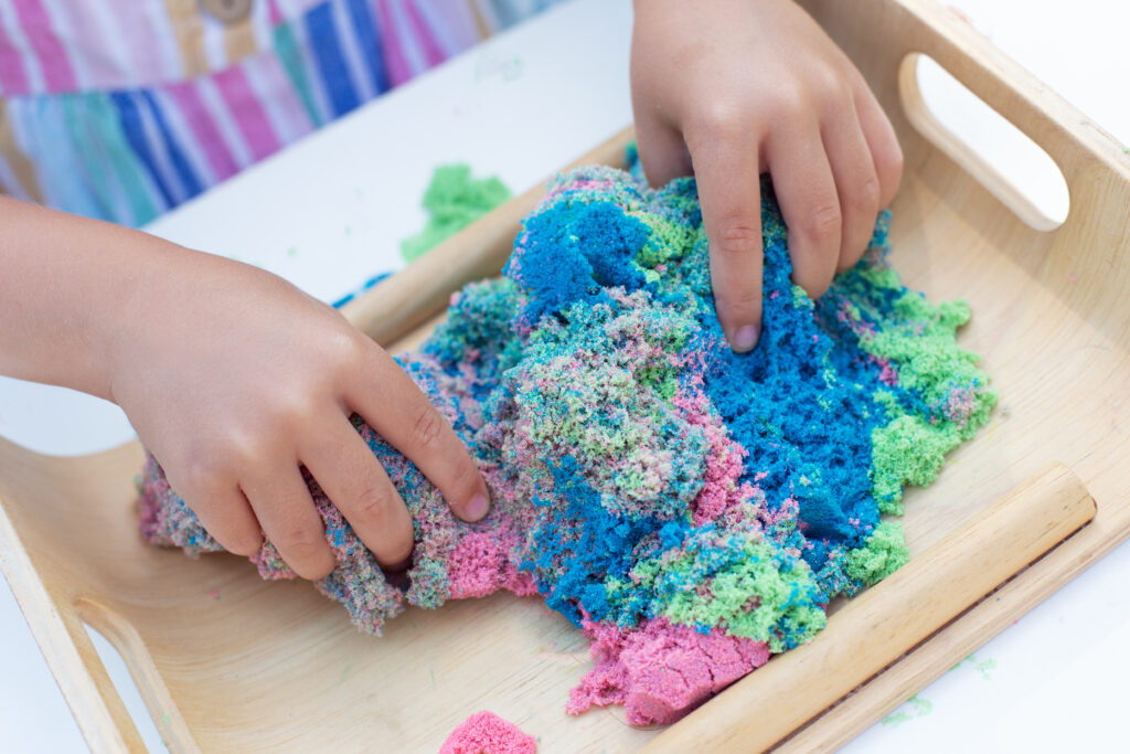 Sensory-Based Approaches for Improving Executive Function Skills in Kids 5 hands little girl playing with kinetic sand close up leisure activity outdoors summer day