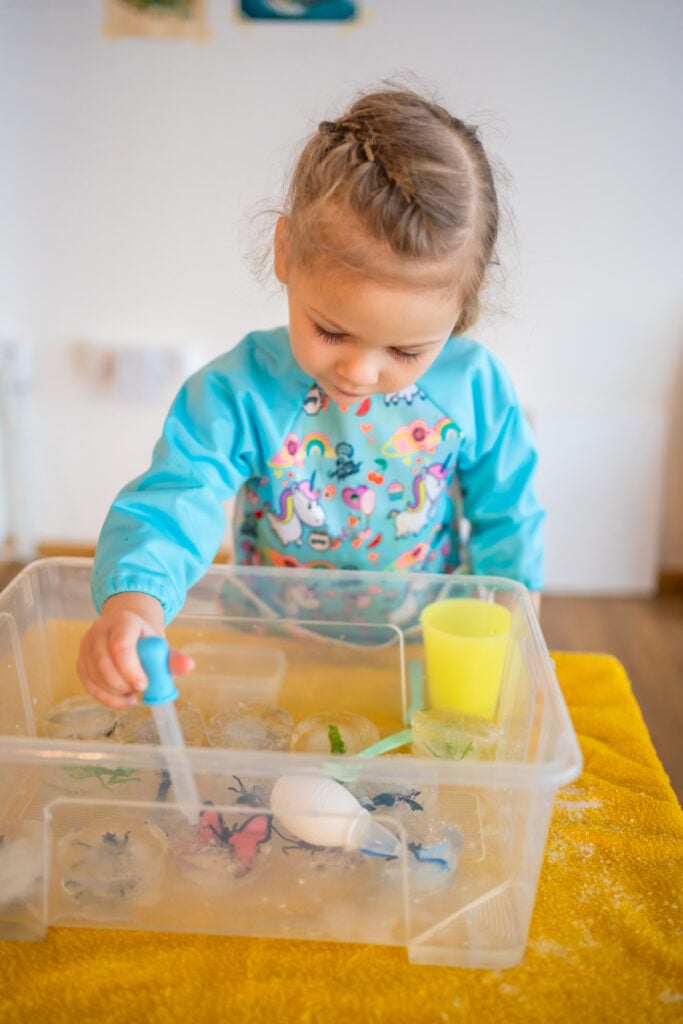little girl melts ice with salt water sensory development experiences themed activities with 1